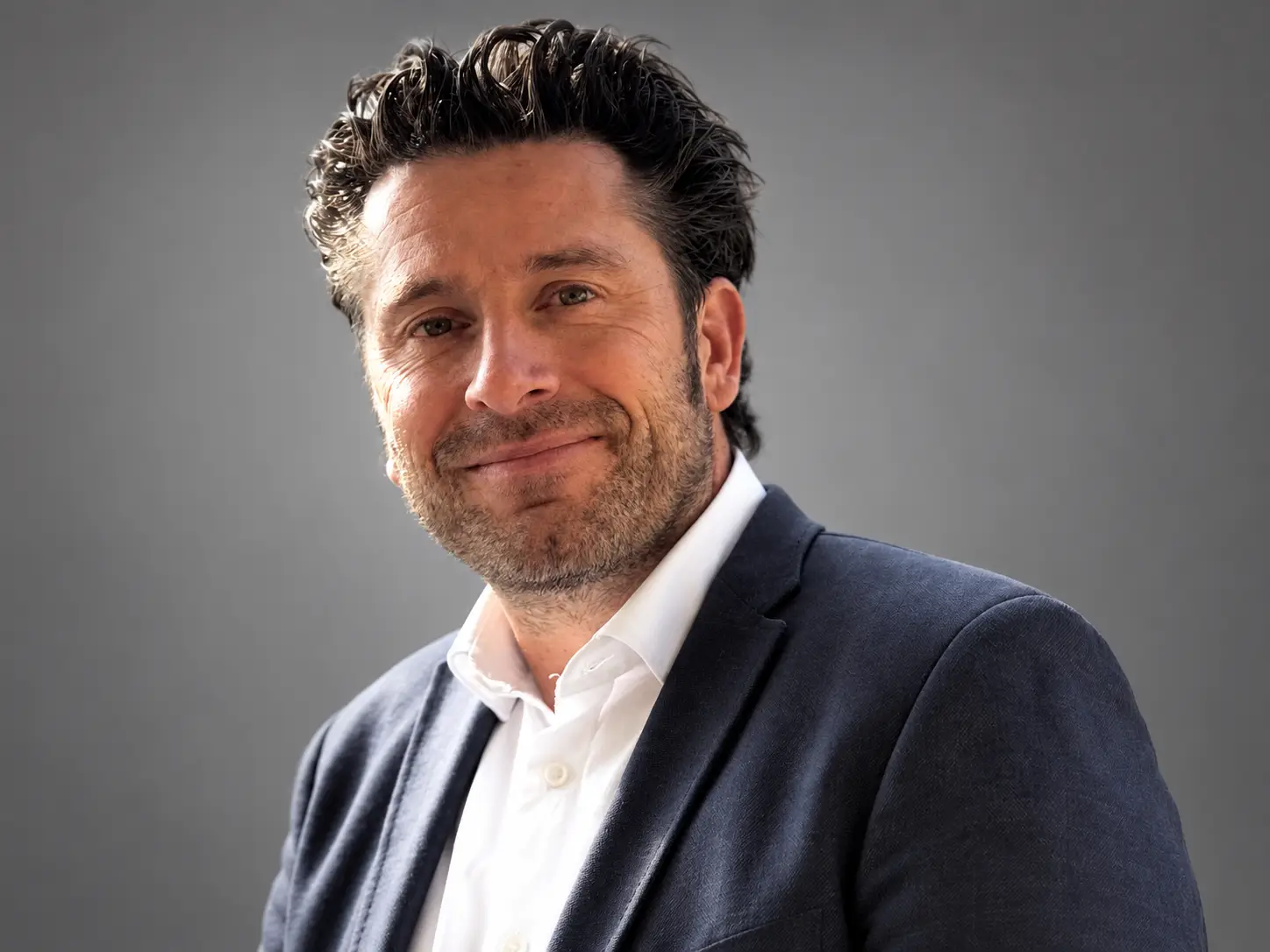 Mag. Pascal Weisang vor grauem Studiohintergrund